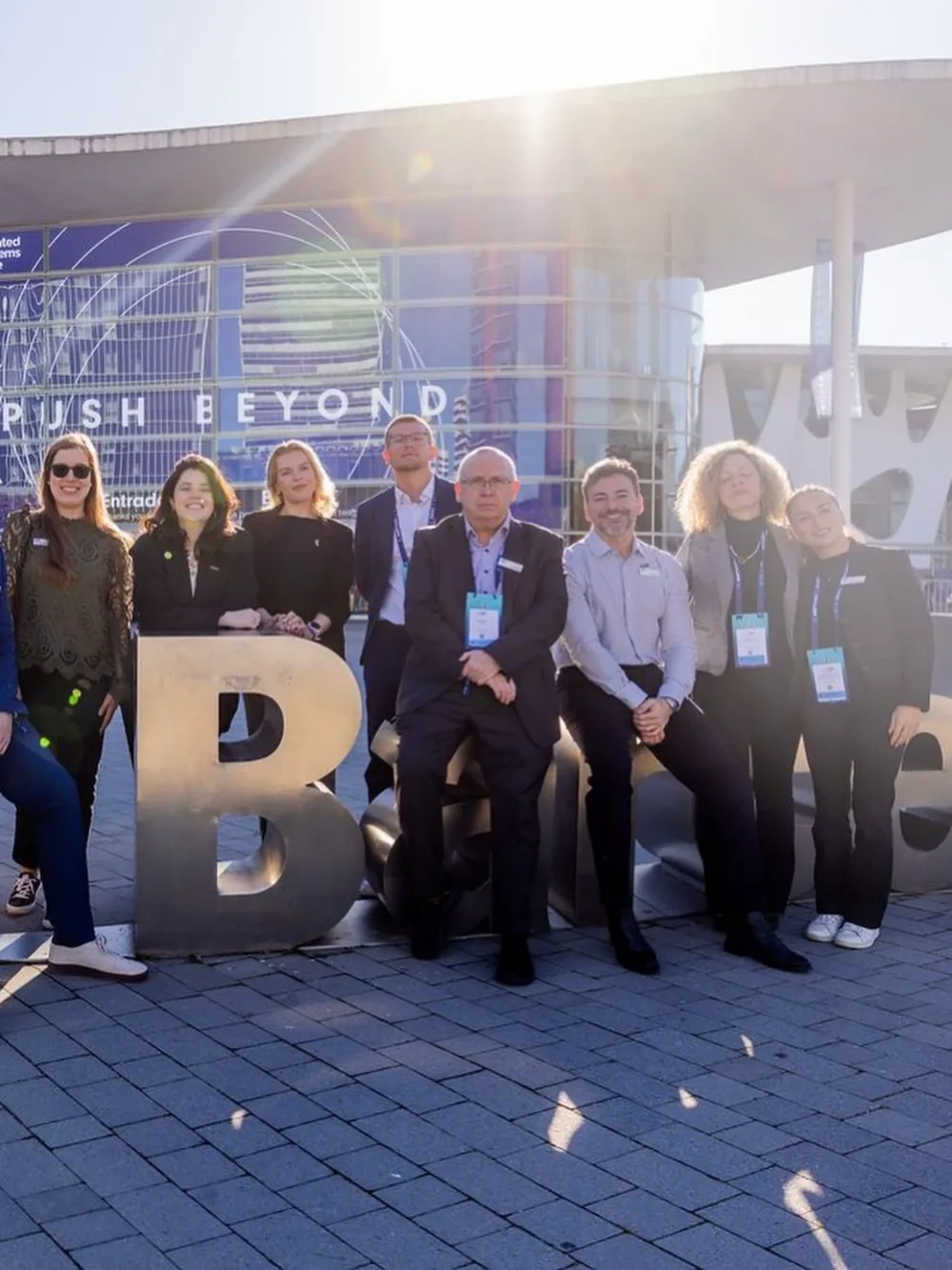 Attendees gathered beside a large letter sculpture under a Push Beyond banner