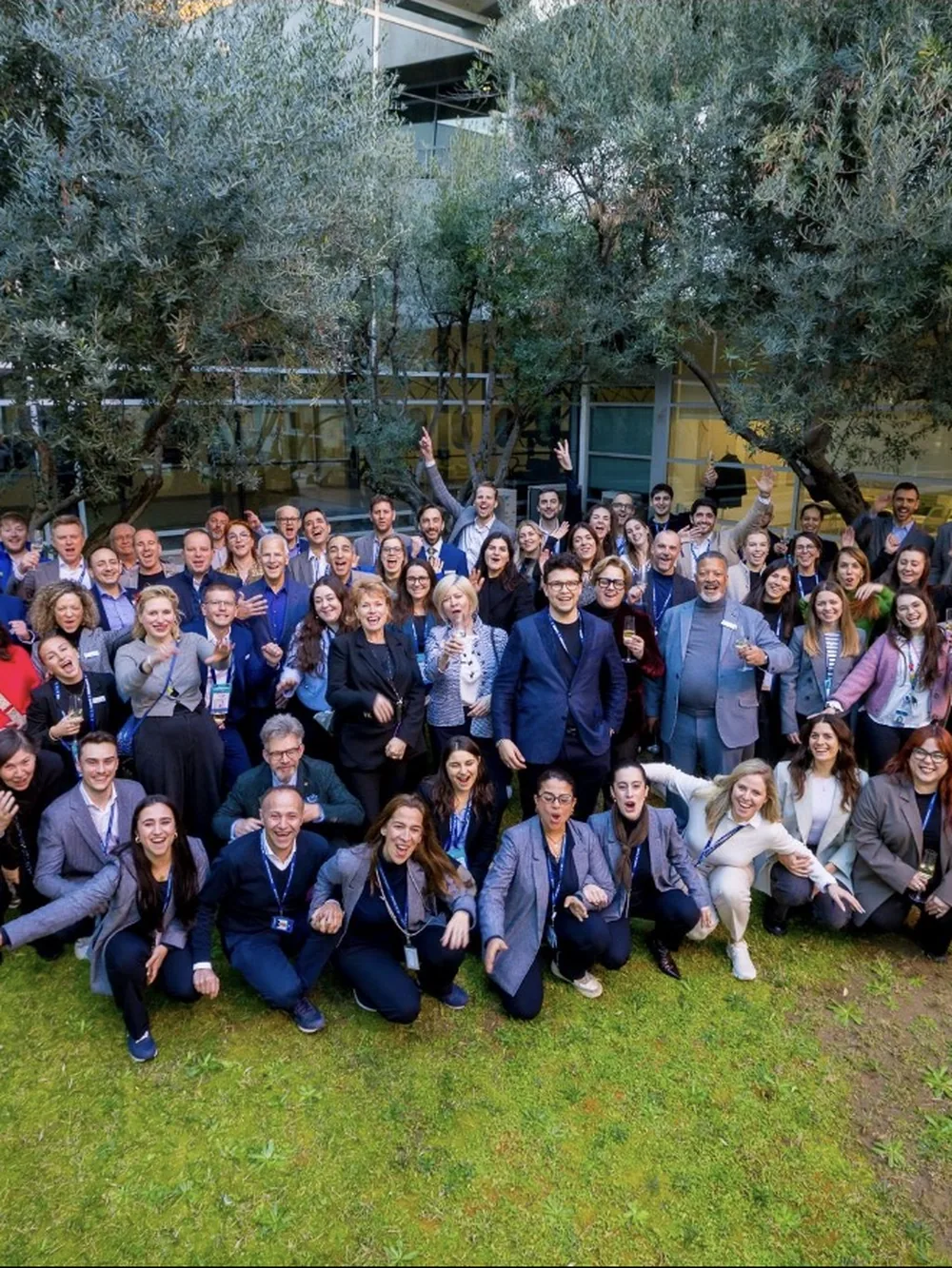 A large conference group photographed together on a lawn